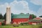 A red barn with a green roof on a summer day in rural Wisconsin.