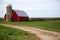 Red barn on a hill with a dirt path