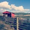 Red barn on hillside with lake, hills and sky background