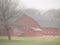 Red barn on misty foggy morning