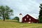 Red barn with round hay bale