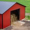 Red barn stacked with hay in a green field