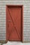 Red barn style door on cedar shakes shingles background