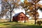 Red barn and tall fall trees