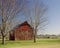 Red barn between tress