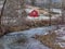 Red barn in winter near a mountain river