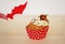 Red bat cupcake decorated with cream and marzipan pumpkin on Halloween