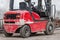 A red battered diesel forklift truck on the street