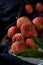 red bayberry(waxberry) and lychee placed together on marble tabletop, dark indoor background