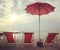 Red beach beds and umbrella on the white beach sunset