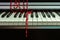 Red beads Christmas decoration lie casually on the piano keyboard