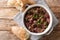 Red bean lobio, with fried onions, garlic and cilantro closeup in a pan. Horizontal top view