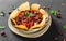 Red bean with nachos or pita chips, pepper and greens on plate over dark background. Mexican snack, Vegetarian food