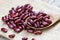 Red bean in wooden spoon on sack background - Grains red kidney beans