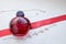 Red beautiful glass transparent fashionable glamorous bottle of female perfumes lying on a red ribbon with a drab white pearls and