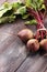 Red Beetroot with herbage green leaves on rustic background. Org