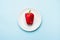 Red bell pepper on a white plate, dieting, healthy food concept. Fresh pepper, health. Food creative concept. Top view Blue Backgr
