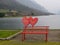 Red bench with heart near the lake Idro, Brescia, Italy