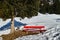 Red bench in snowy field and under fir tree by a sunny winters day