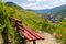 A red bench standing on the hill of the winery, in the background beautiful wineries in the spring.