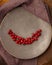 Red berries of fresh hawthorn in a plate standing on a wooden table. Copy space.