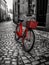 Red bicycle is parked on a cobblestone street