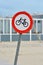 Red bicycle street warning sign on shore of Texel