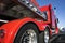 Red big rig semi truck with alumnum flat bed semi trailer standing for rest on truck stop