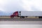 Red big rig semi truck carry refrigeration semi trailer and going by flat road in Utah