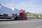 Red big rig semi truck transporting trailers on step down semi t
