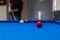 Red billiard ball with a man playing background