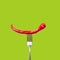 Red bitter chili pepper on the fork on green isolated background. Creative Food concept