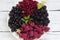 Red and black currants and raspberries and mint, useful ripe berries on a plate