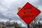 Red and black diamonds shaped sign on a suburban street town reading road worrk. ahead with flashing yellow light on the left side