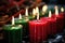 red, black, and green candles burning in a kinara