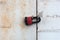 Red and black padlock on an rusty metal gate