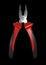 Red-black pliers isolated on black background