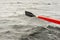 Red and black wooden paddle rowing boat in the lake.