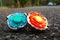 red and blue beyblades are on the asphalt