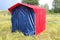 A red-blue homemade tent on a picnic in a forest on grass