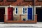 Red and blue neighbor doors in brick walled crew house