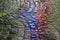 Red and blue neon lights reflected in wet cobblestone on rainy night.