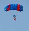 Red and blue parachute with paratrooper in sky