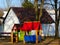 Red and blue playhouse in playground in park like setting