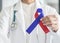 Red Blue ribbon awareness in medical doctor`s hand for Congenital Heart Defects disease, Noonan`s Syndrome, Pulmonary Fibrosis