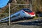 Red blue train in motion alps mountains. High speed mountain train arrives at Switzerland