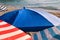 Red, blue and white sun umbrella for sunbathing and protection of sun rays, closeup. Colorful parasol beach umbrella.