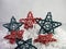 Red and blue wooden stars sitting on a bed of white paper shreds for the 4th of July, Memorial Day or Veterans Day