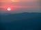 Red blurry sunrise time over Karkonosze mountains. Mist over the range. Poland