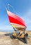 Red boat anchored at stone pier